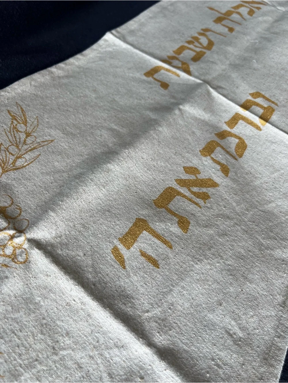 Gold and cream Shabbat tablecloth with gold Hebrew text and illustrations